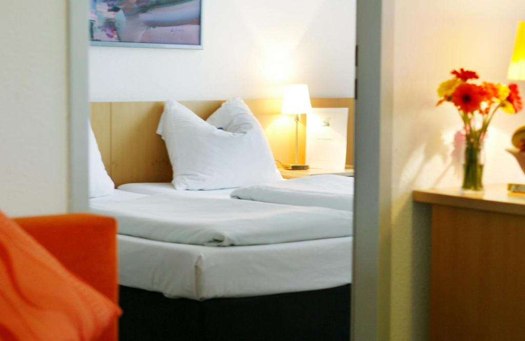 曼海姆阿里瓦博丁普拉塔南花园住宅酒店的酒店客房带两张床和花瓶