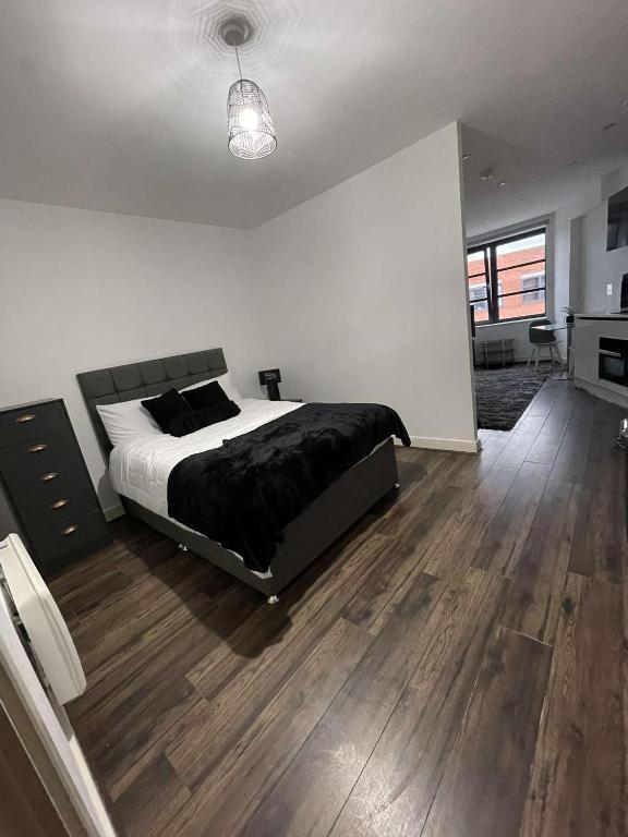 伯明翰One Bedroom Apartment/Studio的一间卧室设有一张大床,铺有木地板