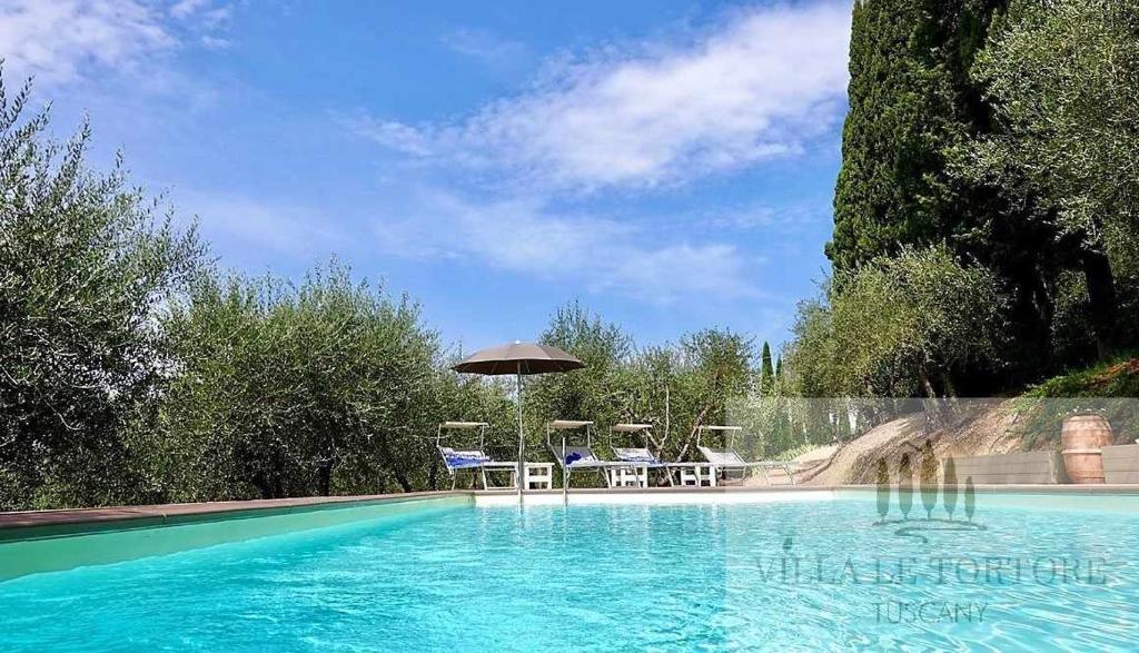 锡耶纳Villa Le Tortore privata lusso piscina relax Siena的一个带椅子和遮阳伞的游泳池