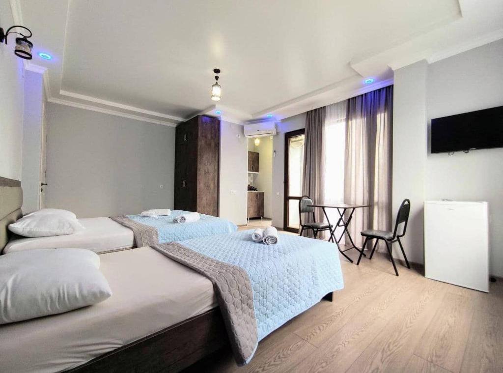 科布列季Elgabi Hotel Kobuleti的一间酒店客房,设有两张床和一间餐厅