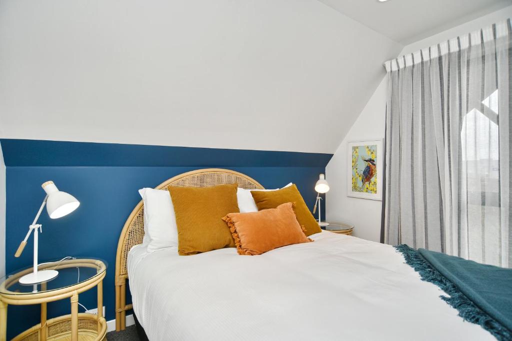 基督城Latimer Loft - Christchurch Holiday Homes的一间卧室设有一张蓝色墙壁的大床