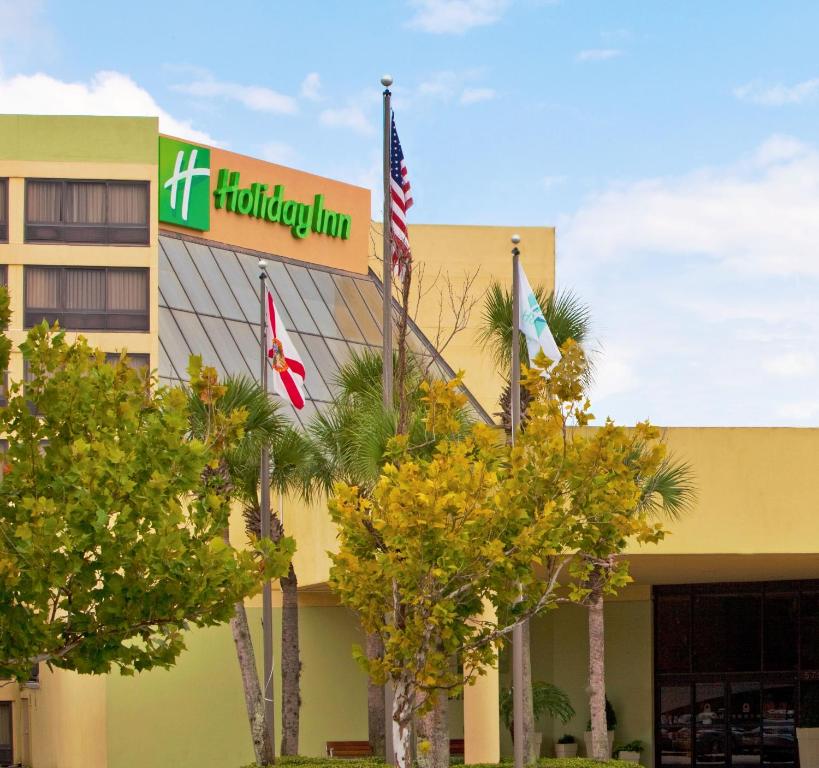 奥兰多Holiday Inn Orlando International Airport, an IHG Hotel的大楼前有旗帜的酒店