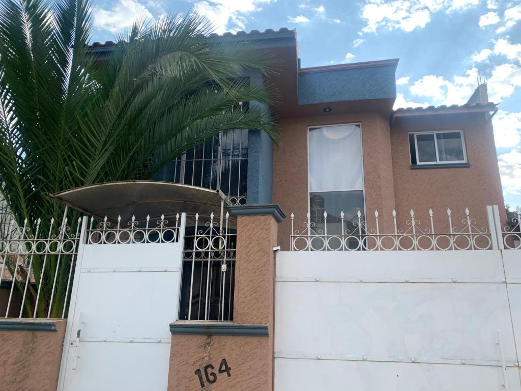 帕茨库卡罗Casa en Pátzcuaro的一座带大门和棕榈树的房子