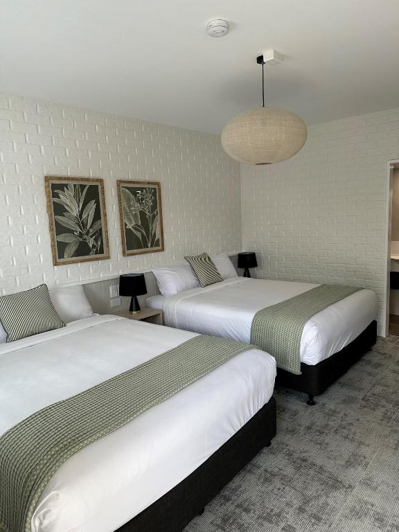 土乌巴三叶草酒店的一间酒店客房,房间内设有两张床