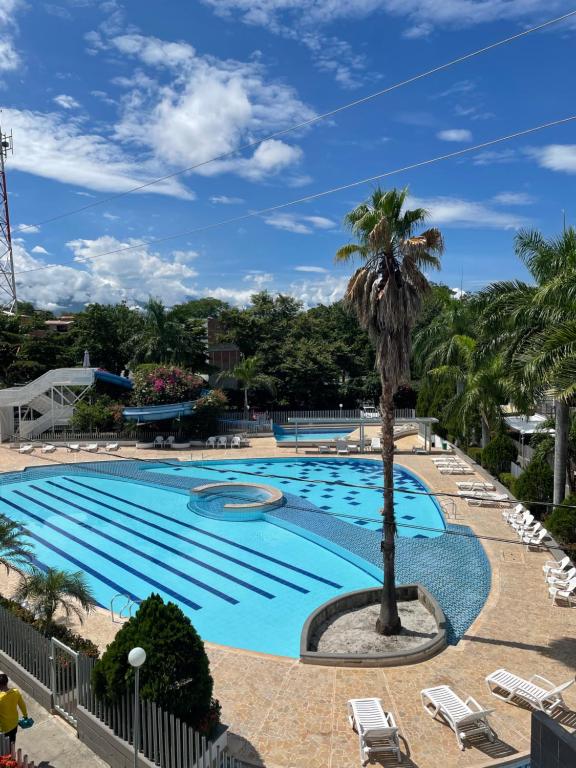 圣菲德安蒂奥基亚Apartasol Santafe de Antioquia 15的度假村内一座带棕榈树的大型游泳池