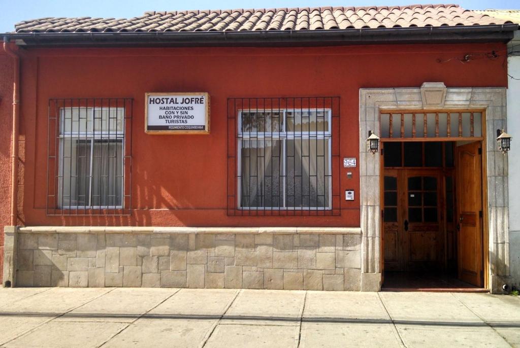 拉塞雷纳Piezas con Baño Privado Economicas的红色的建筑,上面有看医院翻译的标志