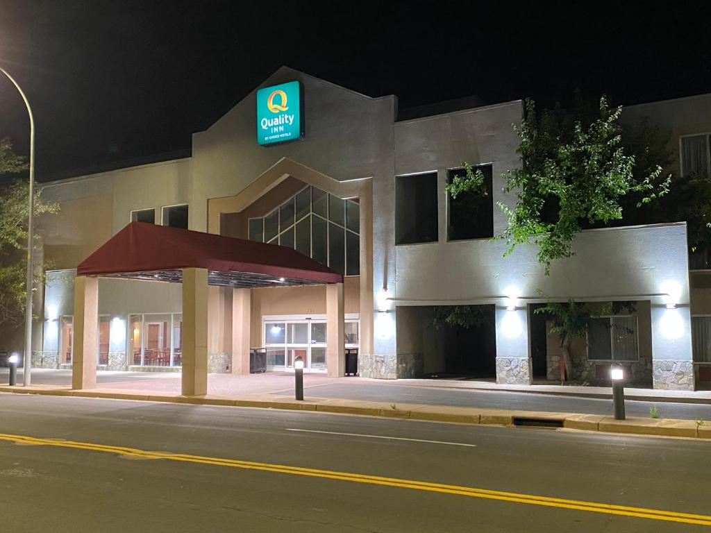 格里利Quality Inn and Conference Center Greeley Downtown的一座晚上有加油站的建筑
