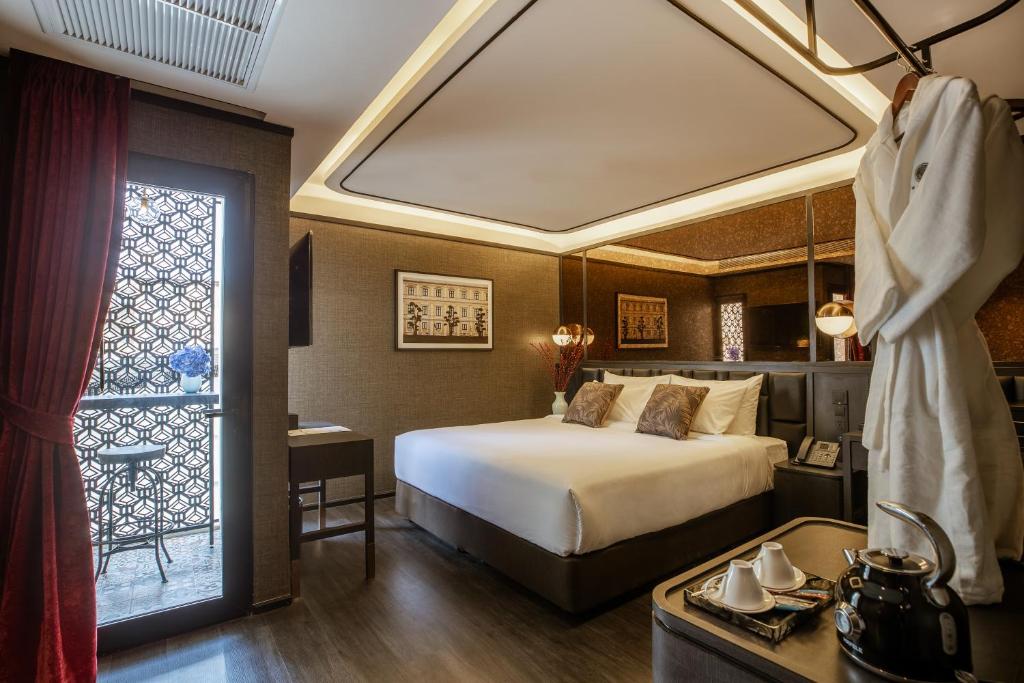 曼谷The Ember Hotel Khaosan的一间卧室设有一张大床和一个窗户。
