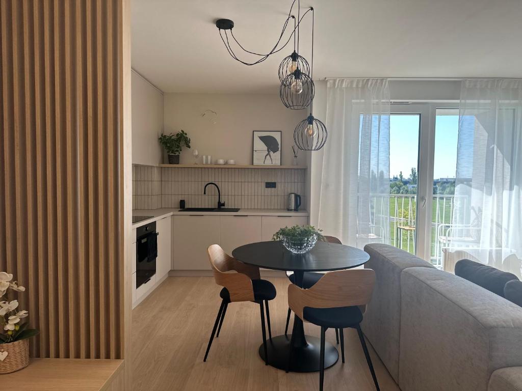 Prievoz3 izbový apartmán hneď pri letisku, možnosť rezervovať parking的厨房以及带桌子和沙发的客厅。