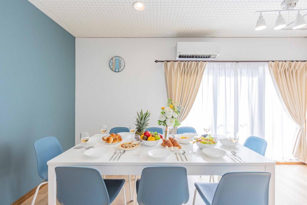 白滨Azami Ann Maisonette的一间配备有白色桌子和蓝色椅子的用餐室
