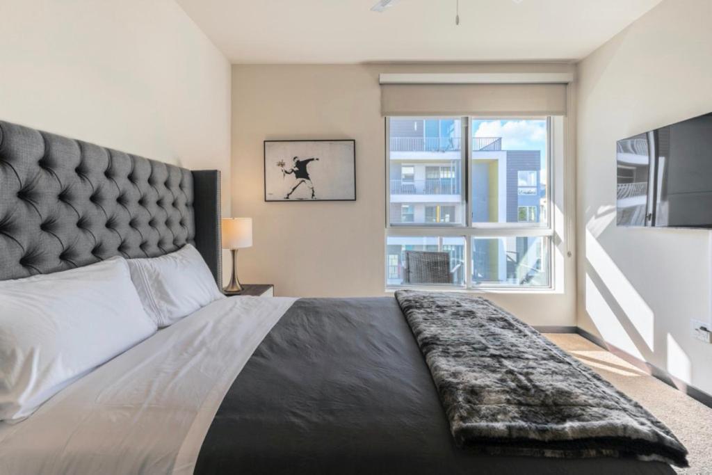 洛杉矶New WeHo Luxury Apartment的一间卧室设有一张大床和大窗户