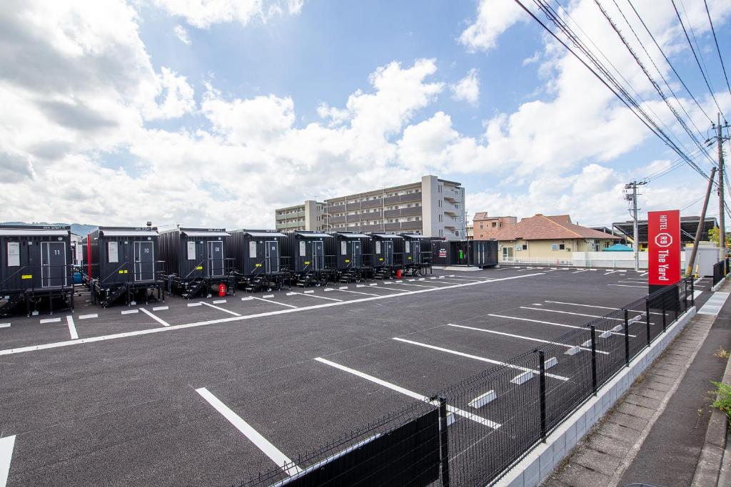 雾岛市HOTEL R9 The Yard Kirishimakokubu的拥有一排火车车厢的停车场