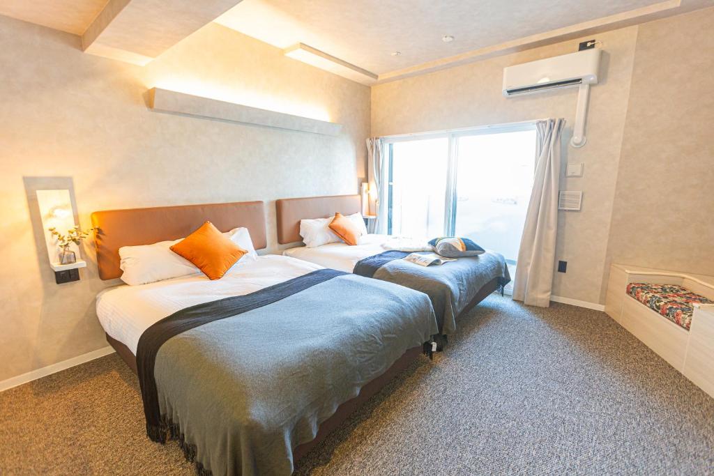 大阪住一梅田店的酒店客房设有两张床和窗户。