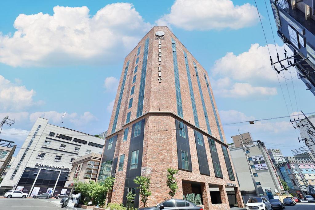 蔚山Brown Dot Hotel Ulsan Samsan的一座高大的建筑,上面有钟