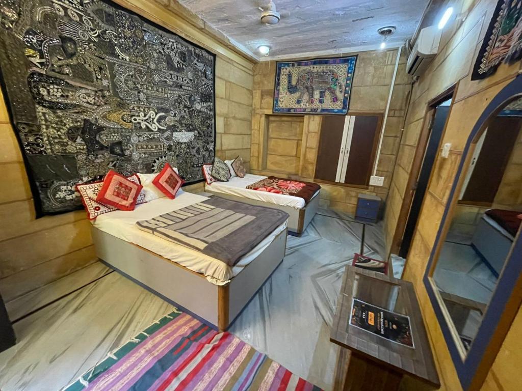 斋沙默尔Hotel Shahiraj Jaisalmer的客房设有两张床和壁画墙