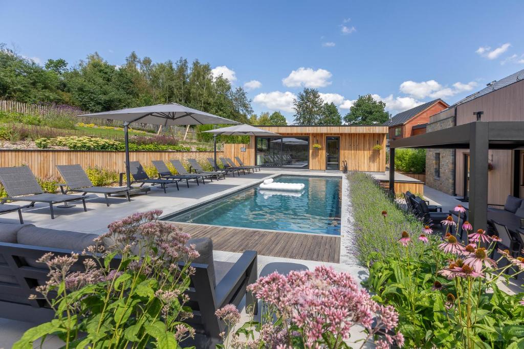 特纳维耶Villa Wood - Gîte de prestige en Ardennes - 10 personnes - Sauna, jacuzzi, piscine et billard的一个带游泳池和庭院家具的花园