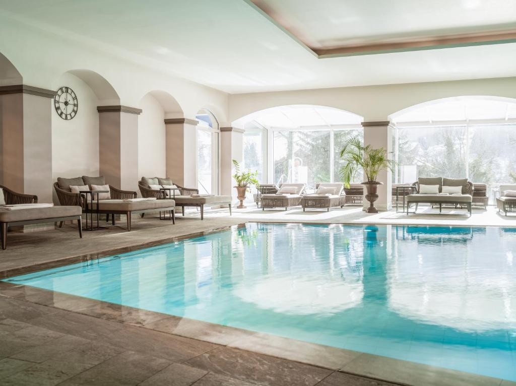 巴德小基希海姆Das Ronacher Therme & Spa Resort的酒店大堂的游泳池,配有桌椅