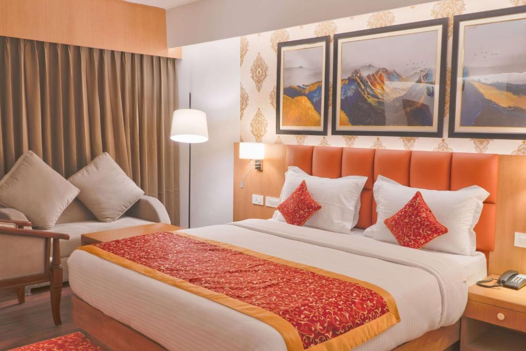 甘托克Days Inn by Wyndham Gangtok Tadong的酒店客房带一张大床和一把椅子