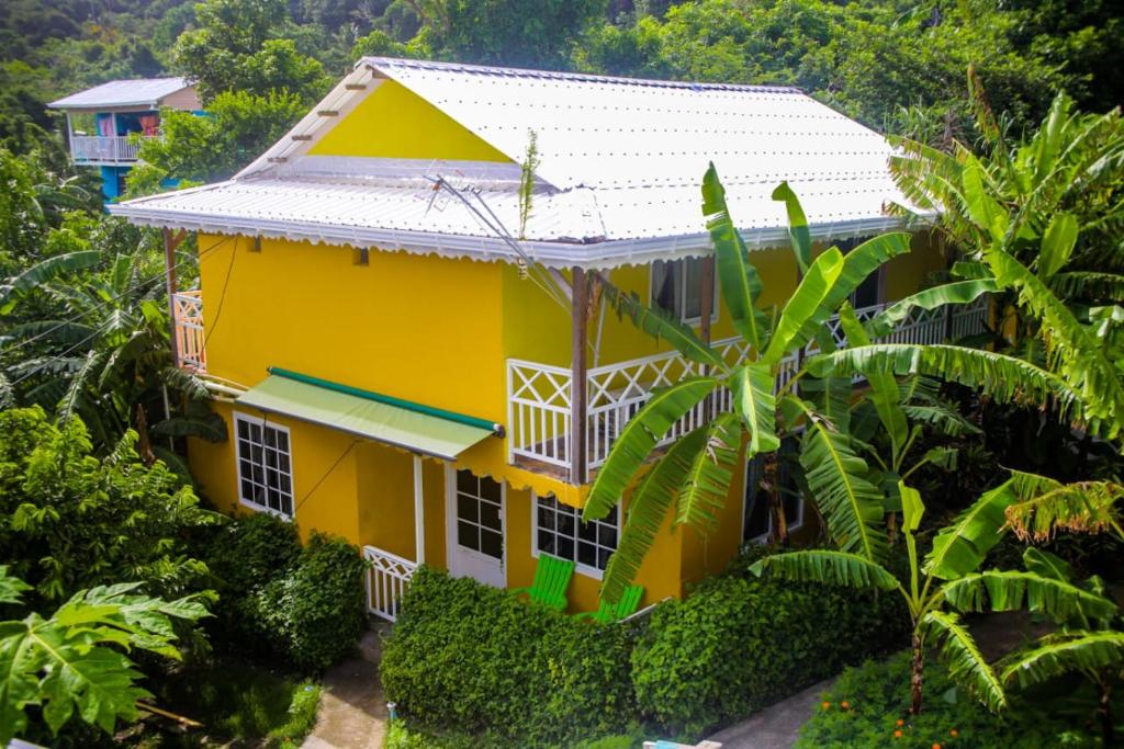 普罗维登西亚Posada Hostel Adri的白色屋顶的黄色房子