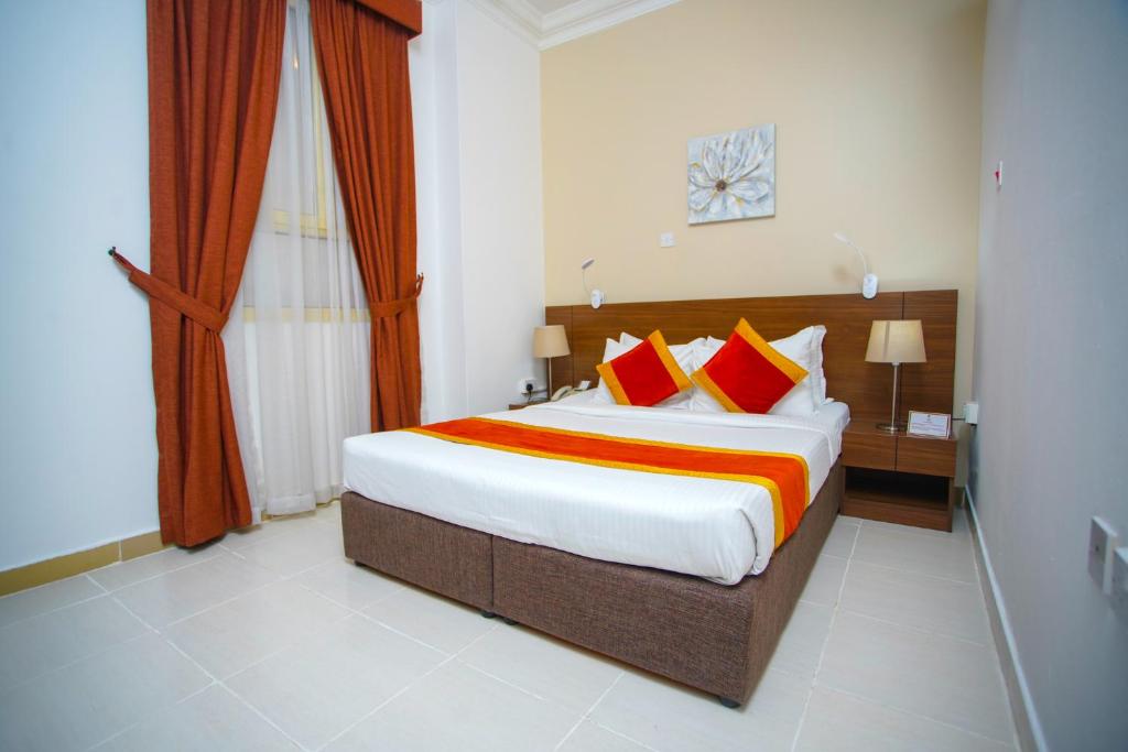 多哈拉维拉酒店的一间卧室配有一张带红色和橙色枕头的大床
