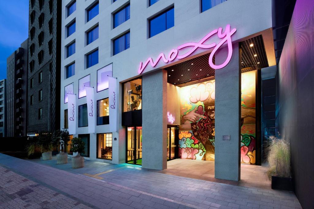 首尔Moxy Seoul Insadong的建筑物一侧有 ⁇ 虹灯标志的商店