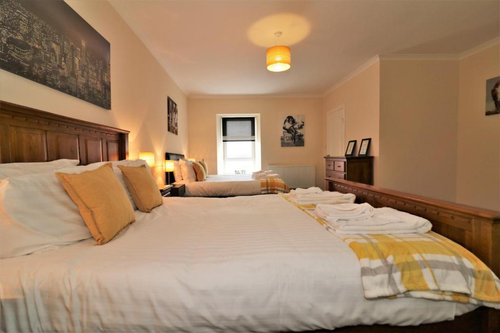KirkmuirhillSignature - Kirkhill House的一间卧室配有一张大床和毛巾