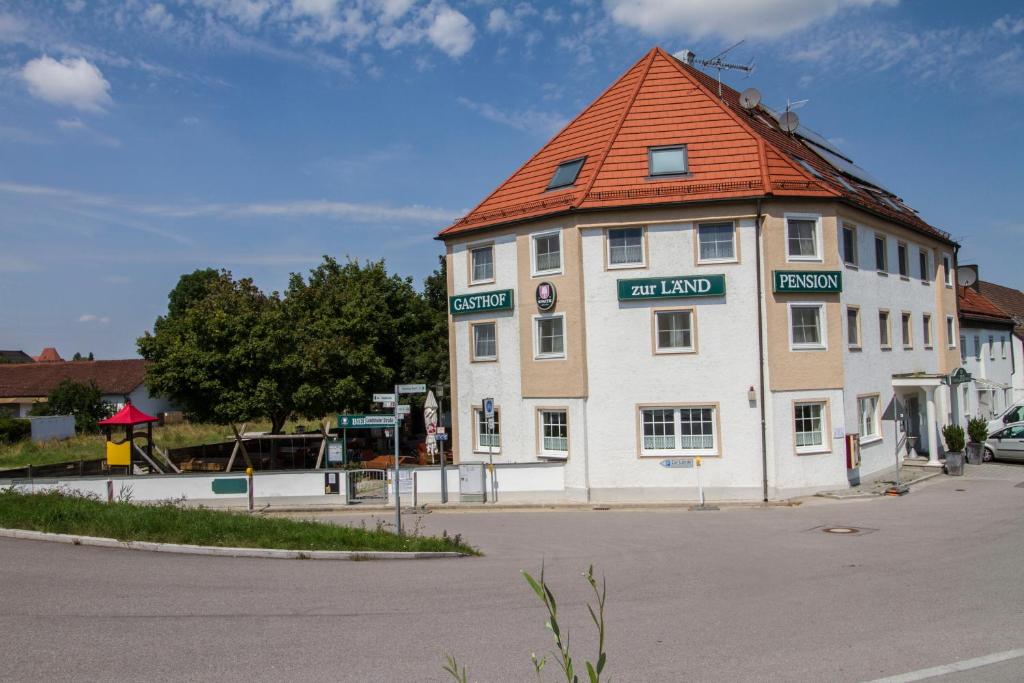 莫斯堡Gasthof zur Länd的一座白色的大建筑,有橙色的屋顶