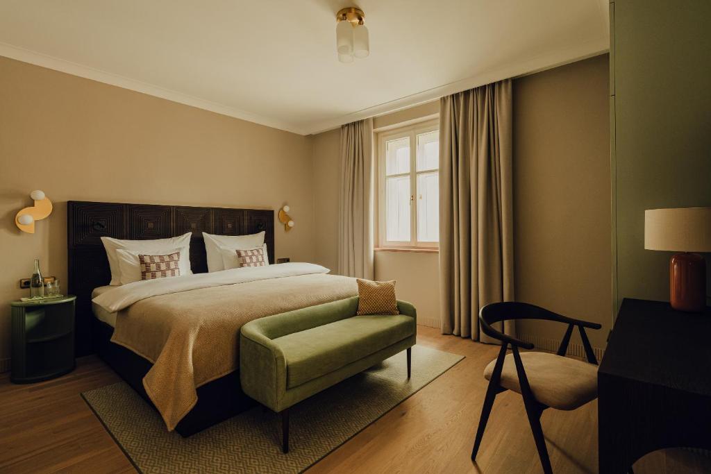 萨尔茨堡Hotel Zum Hirschen Salzburg的卧室配有床、椅子和窗户。