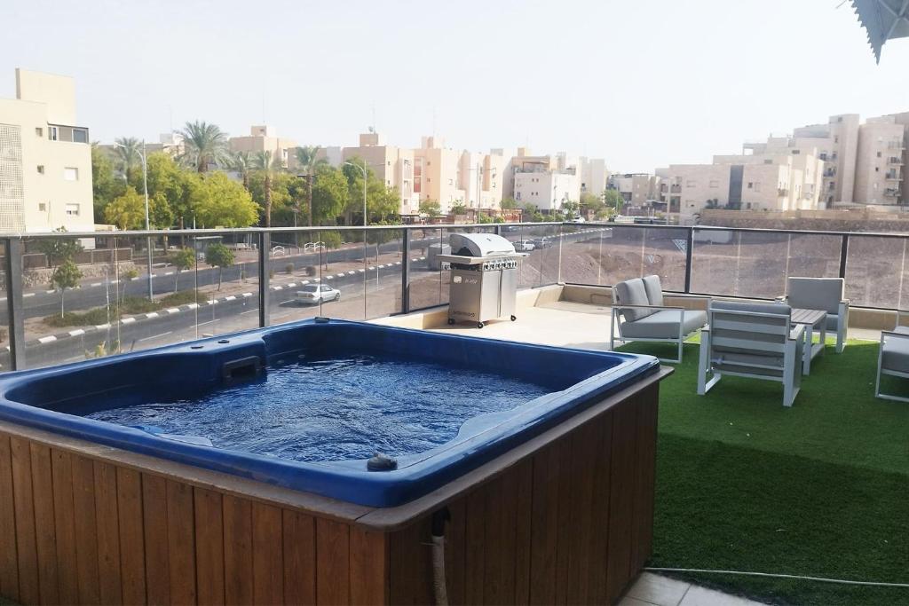 埃拉特YalaRent Seasons 4 bedroom apartment with jacuzzi的市景阳台的热水浴池