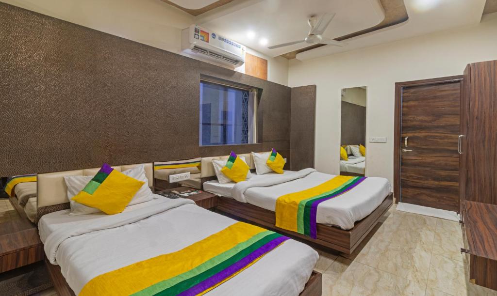 范兰德凡Itsy By Treebo - Shree Anand Dham, Vrindavan的酒店客房配有两张带色彩缤纷枕头的床。