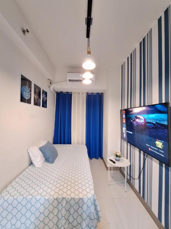 马尼拉Coast Residence Pasay的一间卧室配有一张床和一台平面电视