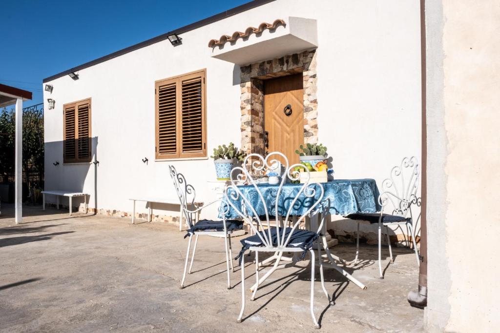 卡尔塔尼塞塔Un posto al sole - Caltanissetta的房屋前设有带桌椅的天井。