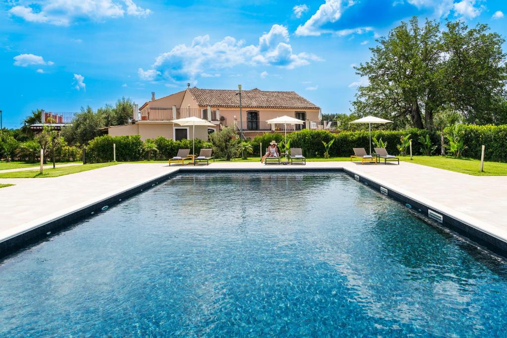 卡塔尼亚Nèroli Bio Relais的一座带房子的庭院内的游泳池