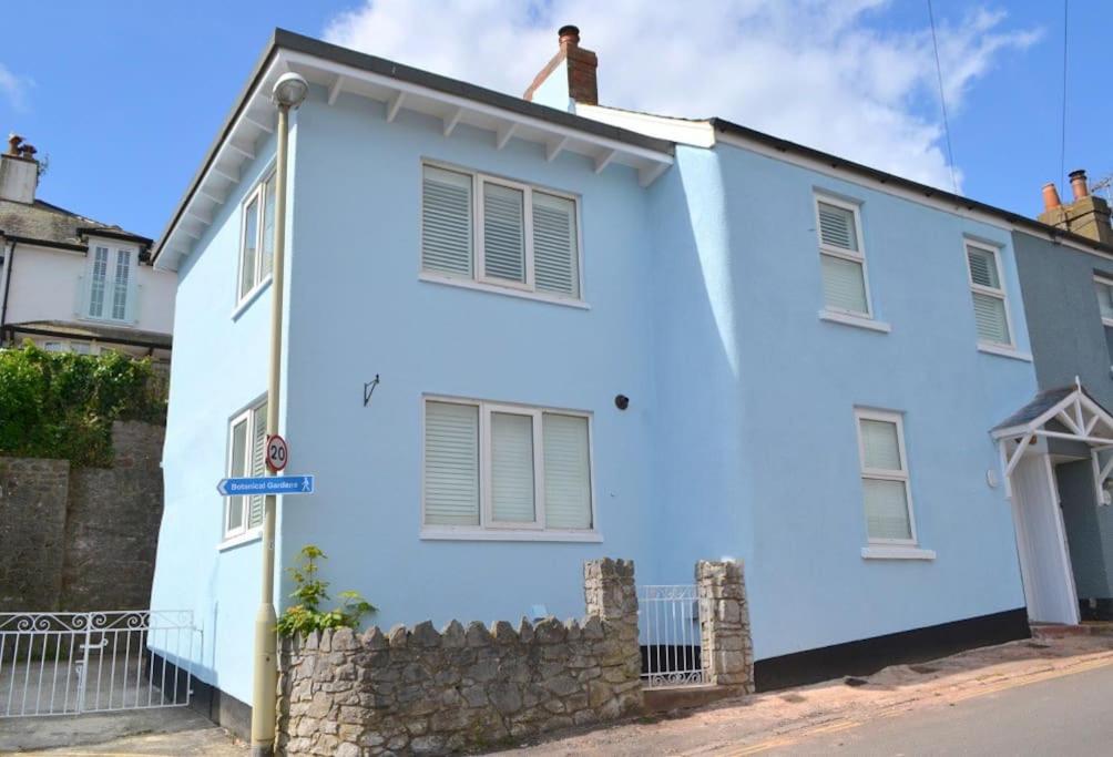 沙尔顿Delightful Dog Friendly Seaside Cottage in Shaldon Devon的站在白色房子屋顶上的男人