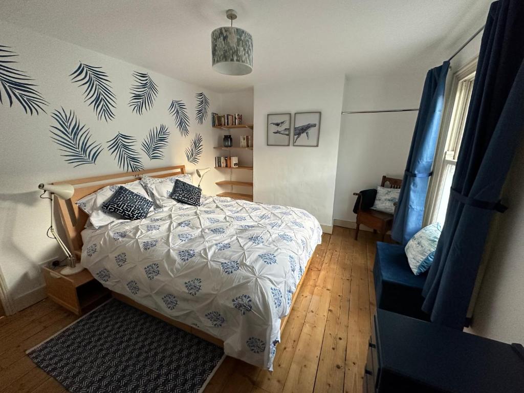 剑桥Beautiful Victorian house in central Cambridge的一间卧室配有一张带蓝色和白色棉被的床