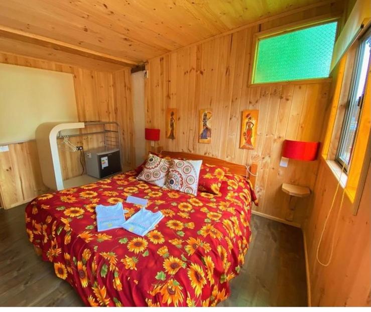 黑岛FULL SPA ISLA NEGRA Suites的木制客房内的一间卧室,配有一张床