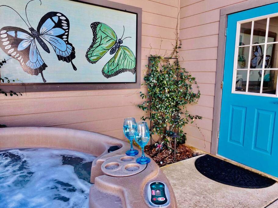 阿赫瓦尼Butterfly Suite Hot Tub BBQ Private的一个带热水浴缸的度假屋,墙上挂着蝴蝶