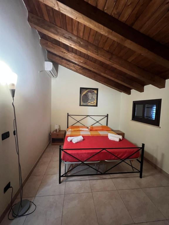 诺托玛丽娜Casa vacanze Arianna的一间卧室设有一张红色的床和木制天花板