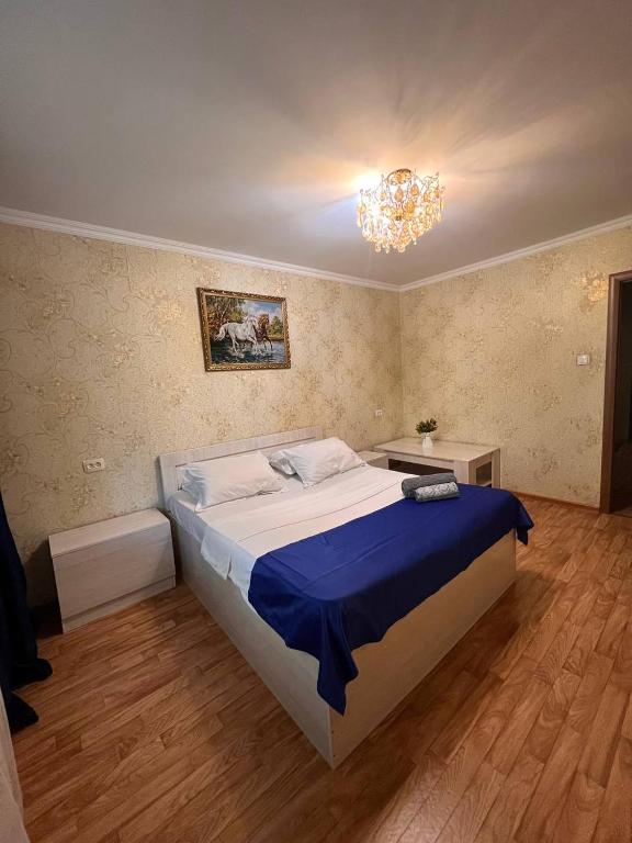奇姆肯特Апартаменты на Mege的一间卧室配有一张大床和一个吊灯。
