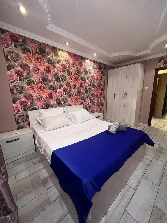 奇姆肯特15 Apartments的一间卧室设有一张带花卉墙壁的大床