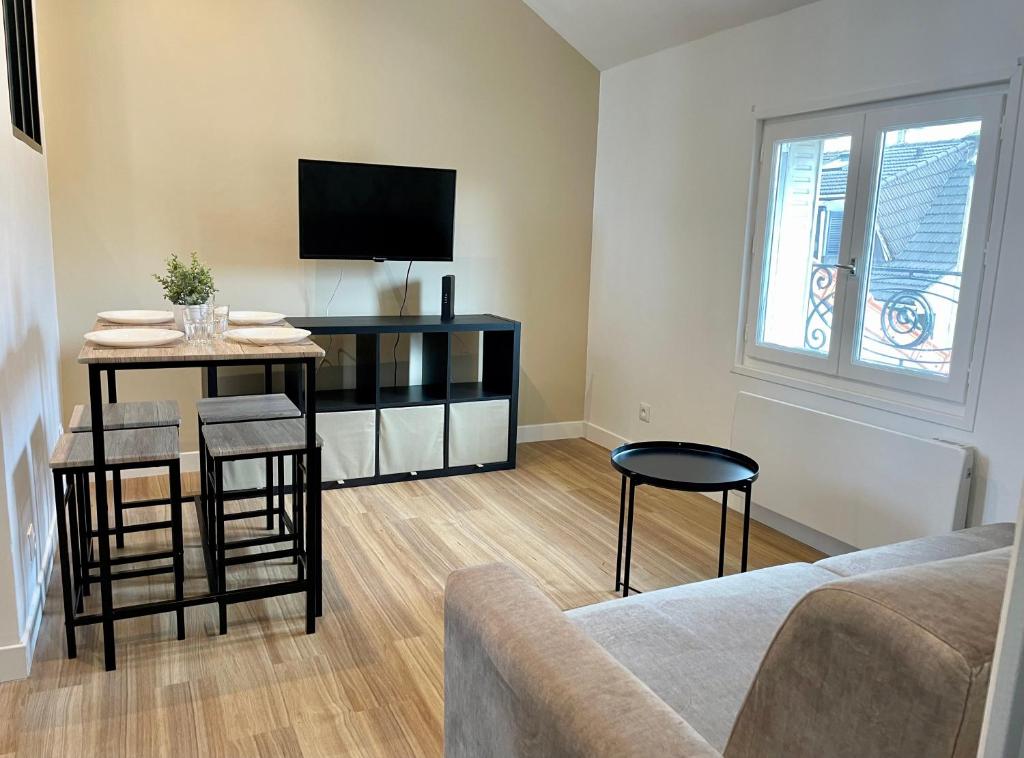 勒布尔热Le Cocon - logement 4 personnes - Neuf - Wifi的客厅配有电视和桌椅