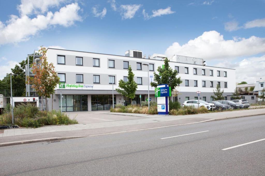 慕尼黑Holiday Inn Express Munich - Olympiapark, an IHG Hotel的街道边的白色建筑