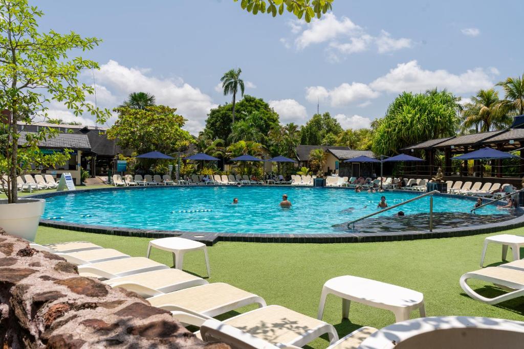 帕拉马里博Torarica Resort的一座带白色椅子的大型游泳池,里面的人