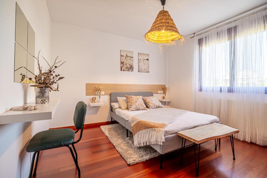 圣地亚哥－德孔波斯特拉Wasi Compostela的卧室配有1张床、1张桌子和1把椅子