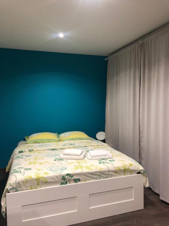 MeythetGrand studio的一间卧室配有一张蓝色墙壁的床