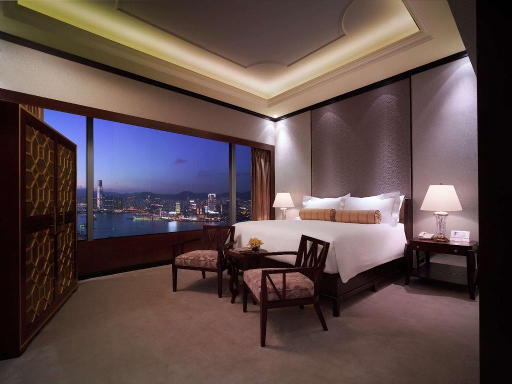 香港香港港丽酒店的一间卧室配有一张床和一张桌子及椅子