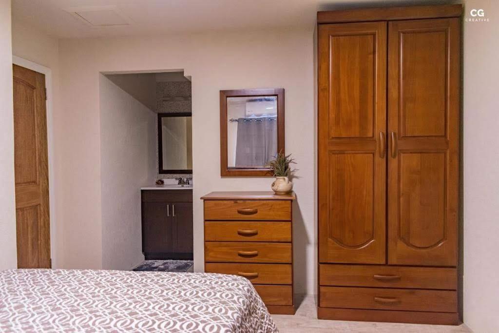 格兰德海滩SkylineSuites Lost in Paradise - FA3的一间卧室设有梳妆台和大型木制橱柜。