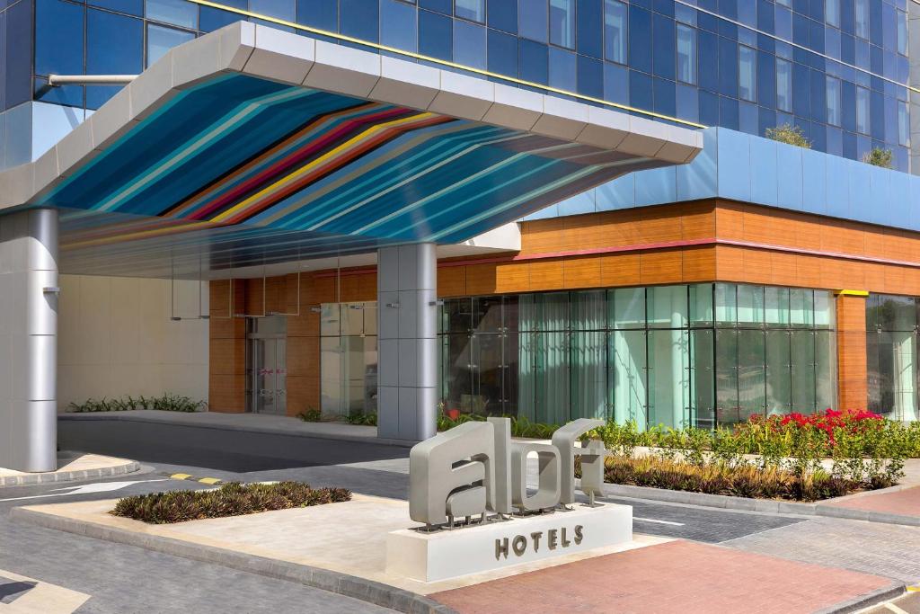 迪拜Aloft Al Mina, Dubai Jumeirah的建筑前有标志的酒店
