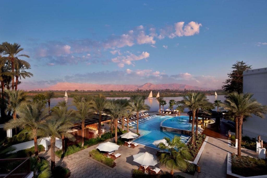 卢克索希尔顿卢克索Spa度假酒店的享有带游泳池和棕榈树的度假村的顶部景致