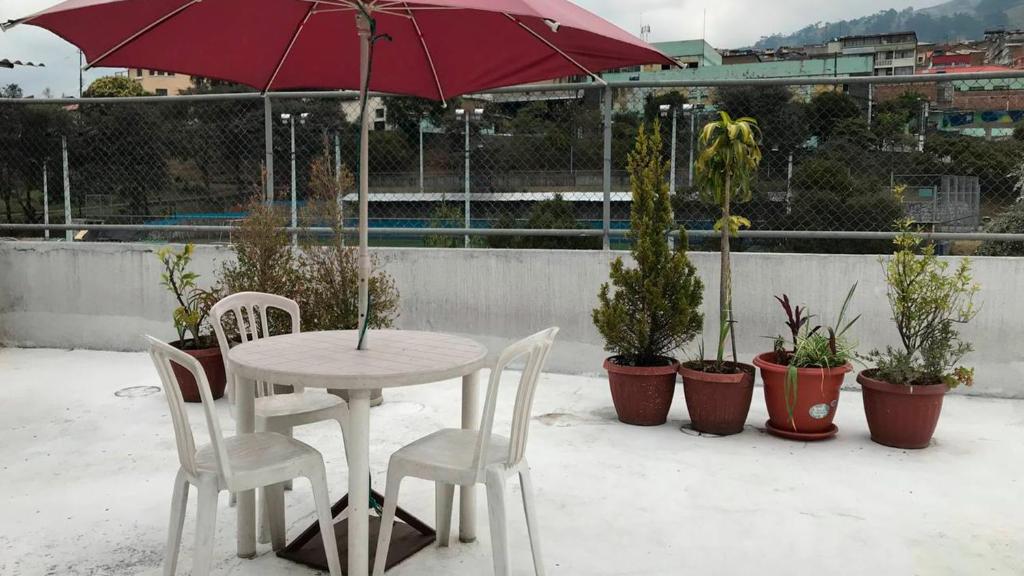 基多Tin House Quito的桌椅,带雨伞和盆栽植物